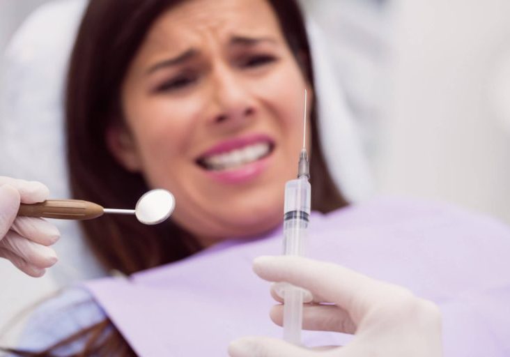 dentist-holding-syringe-front-scared-patient